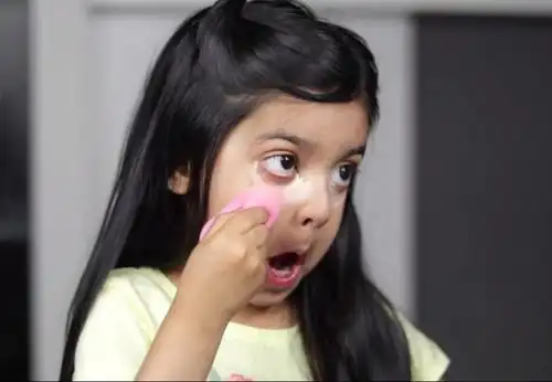 接着,她很干脆利落地在她的黑眼圈上涂上了一大笔遮瑕液,用海绵蛋轻轻