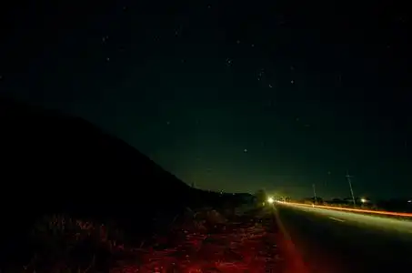 美丽的夜晚的星星在天空和山脉轮廓近路车步道景观.