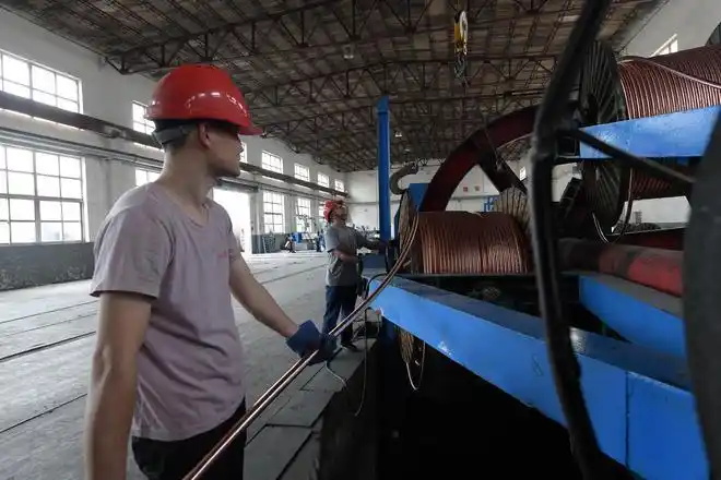 图为在文安县大围河乡兴盛山鹰电线电缆有限公司工人正在生产电缆.