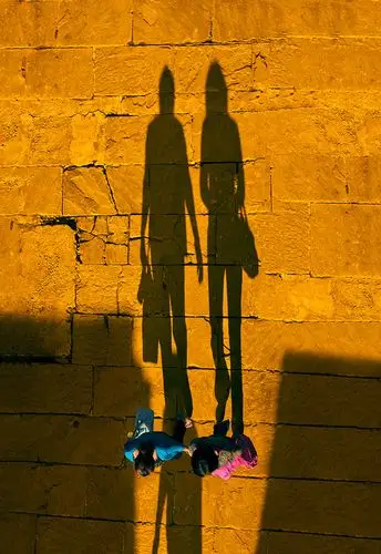 落日余晖洒在她们身上,长长的影子印在石板上.