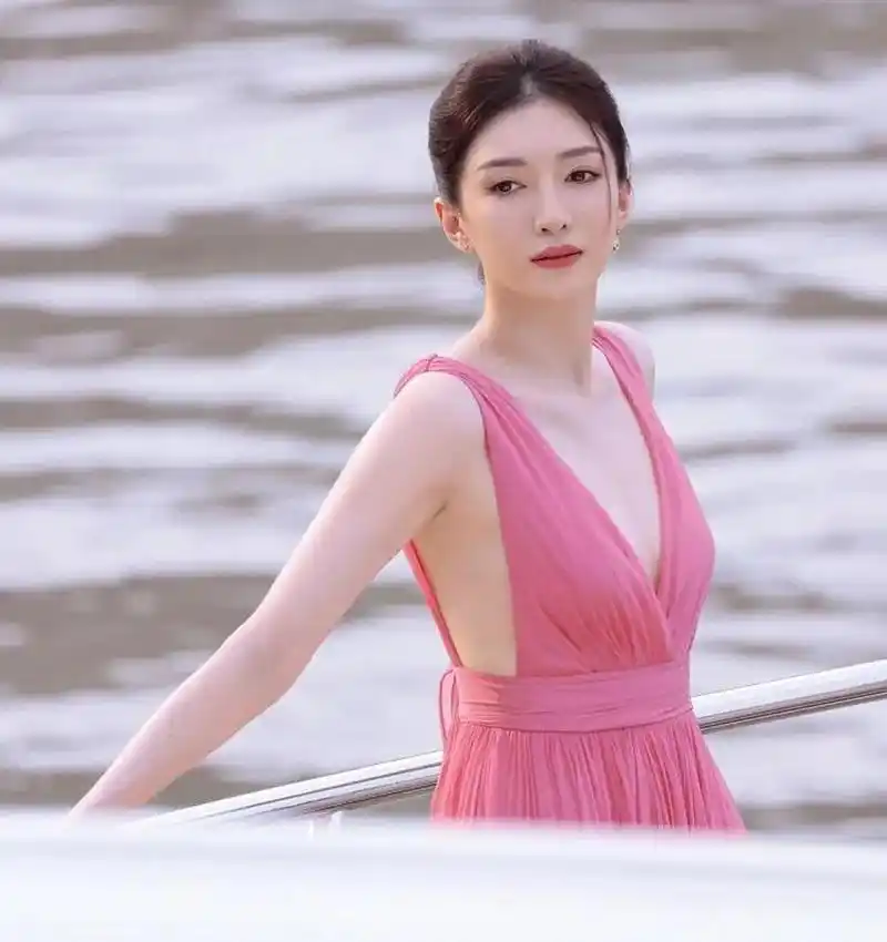 江疏影身穿玫红色长裙站在海边,展现出一种纯净而迷人的气质.