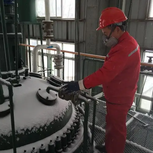 化工厂生产班员工在清理车间门前积雪准备组织生产高温交联剂