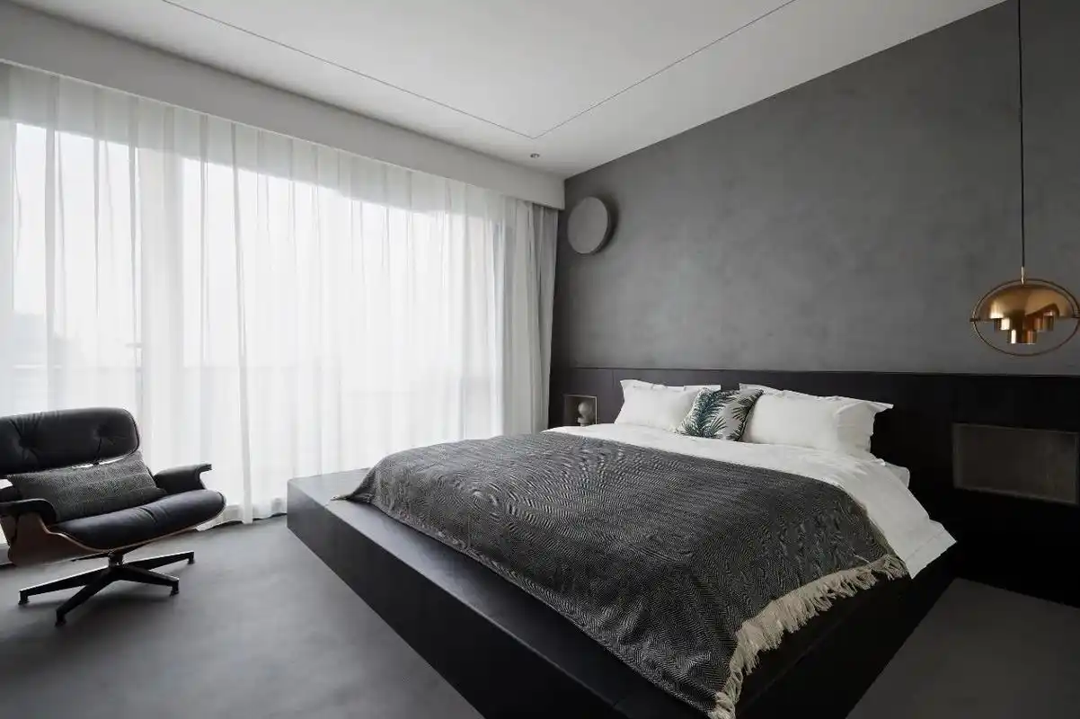 主卧以深灰色奠定空间的基本色调,床头垂吊灯具线条流畅,让整个空间更