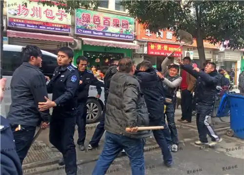 武汉欢乐大道东湖庭园小区门口,城管队员与水果店商贩当街打架,有人