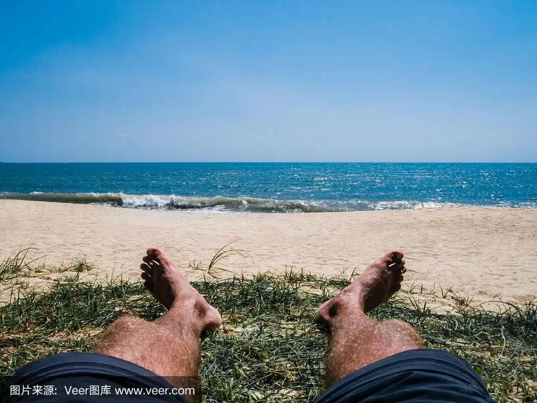 享受大海.在沙滩上晒太阳的男人