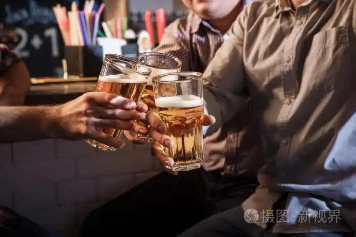 快乐的朋友在酒吧柜台喝啤酒