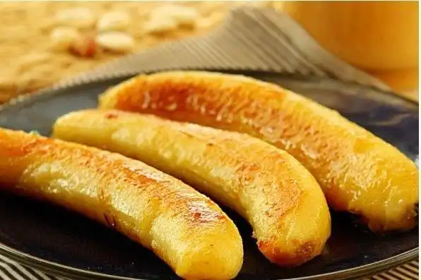 蜜烤香蕉.平底锅放油烧热后,将去皮的香蕉放入平底锅中.