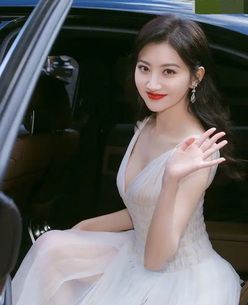 景甜在白色深v吊带连衣裙中展现出了她的女神气质和自信.