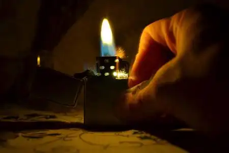 一个打火机在黑暗背景下发出蓝黄光和火花的特写镜头.照片