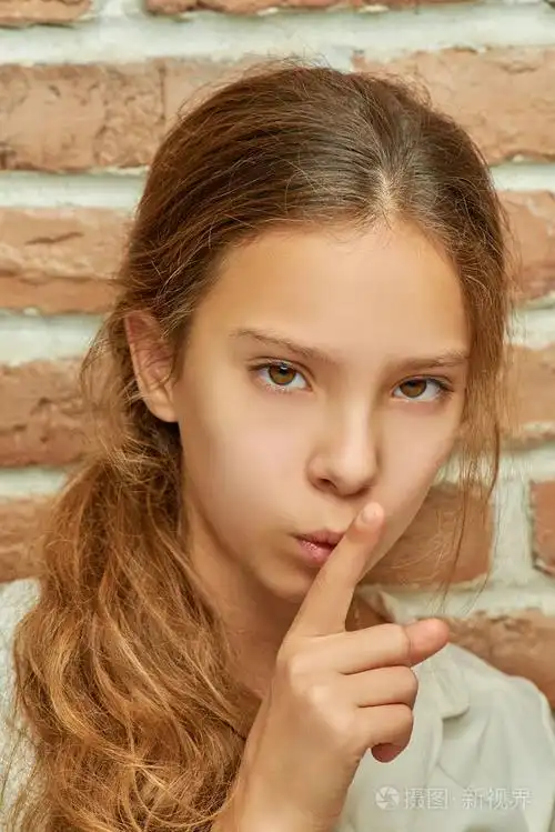 留着长发的少年女孩呼吁对砖墙保持沉默.
