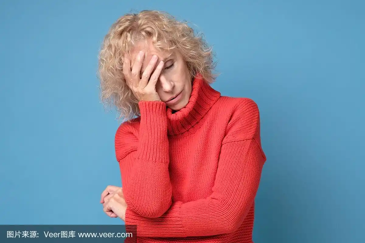 精疲力竭的老女人用手捂着额头