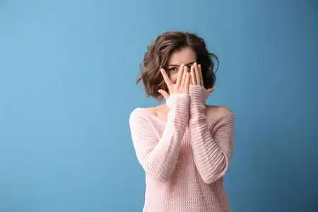 彩色背景上双手捂脸的美女肖像照片