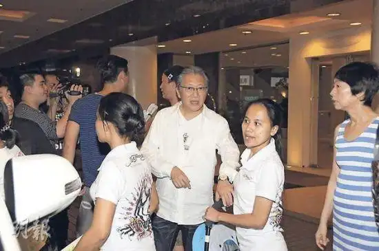 郑东汉(右)参加孙女的生日会,儿子郑中基在身后大方接受访问.