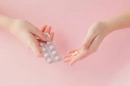 粉色药片粉色药片在粉红色背景上的女人手上.俯视图.平躺.复制空间.