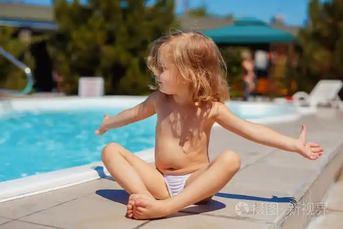 小女孩在户外附近的游泳池锻炼.健康的生活方式.瑜伽