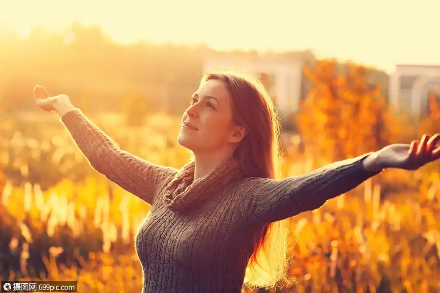 轻浪漫的女人享受着温暖的秋天天气感自由积极充满活力的日落颜色