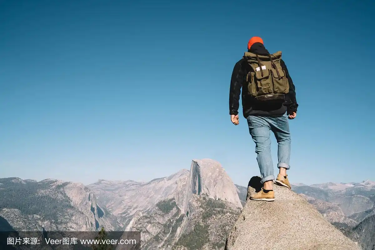 男性旅行者的背影与旅游背包得到岩石悬崖观察风景从顶部,潮人漫游者