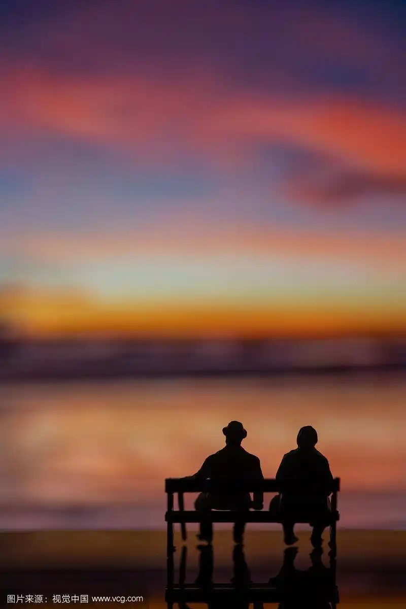 夕阳下坐在长椅上的老夫妻模型