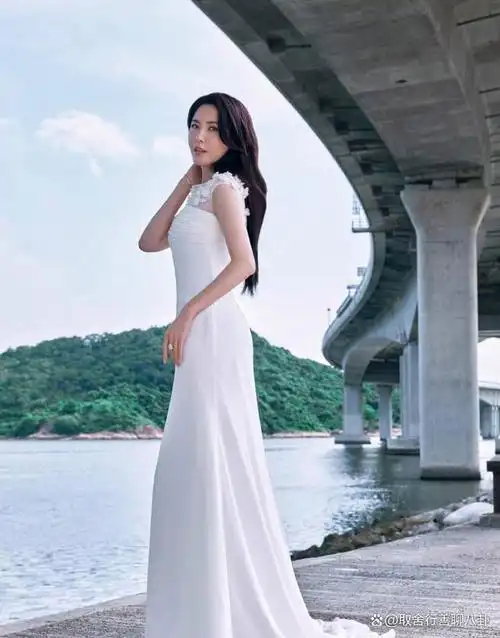 曾黎穿白色连衣裙赤脚坐在碎石上,性感双唇迷人,画面非常漂亮