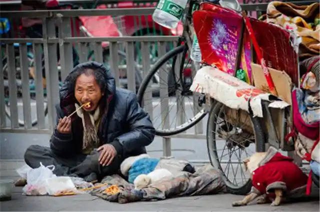 乞丐路边乞讨,小孩给了5元零钱,乞丐感激收下,数钱后立马报警