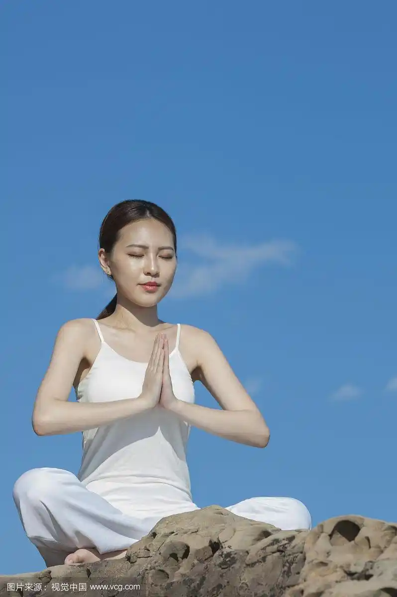 在岩石上打坐的漂亮女人