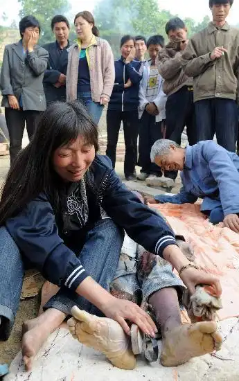 图文:母亲在为儿子的遗体擦去灰尘