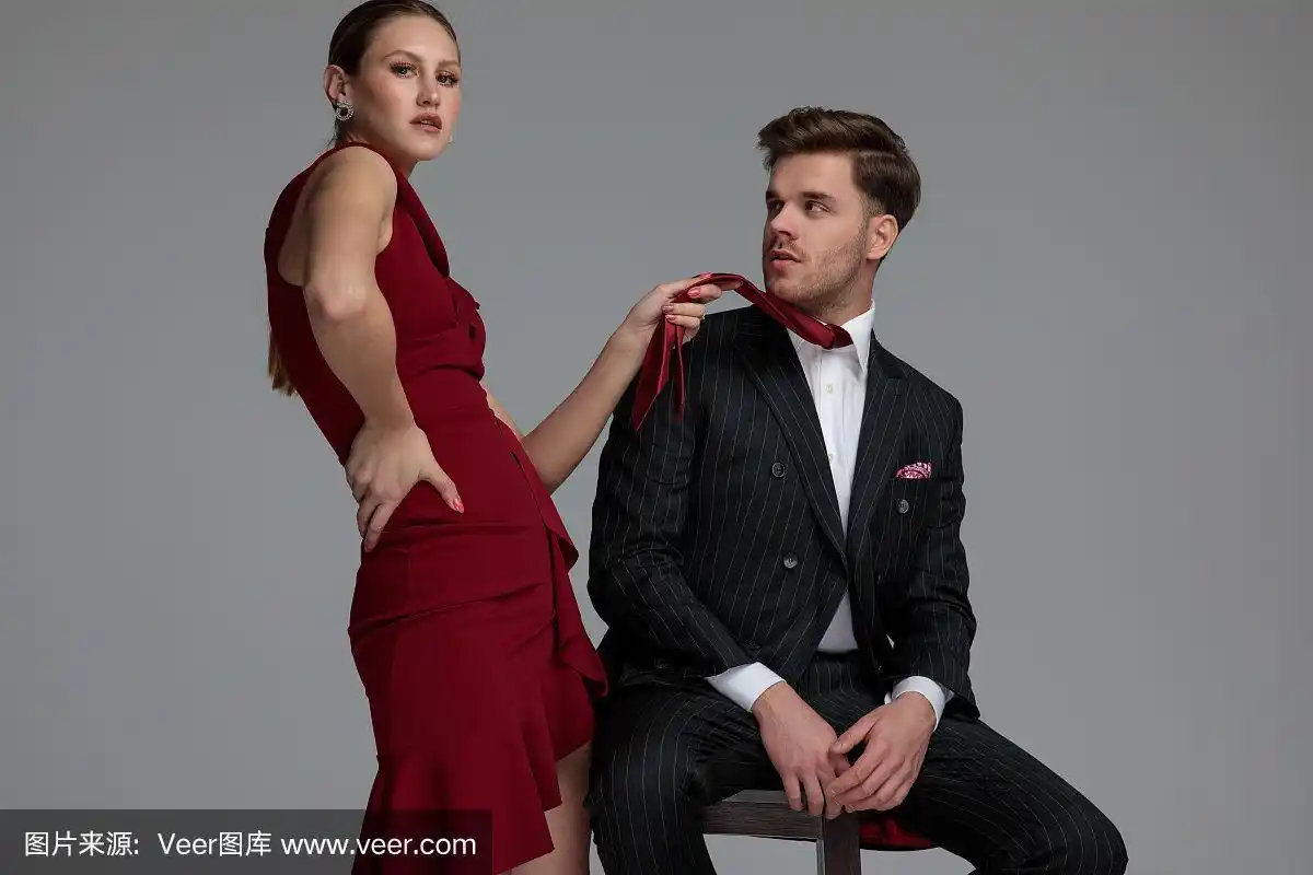 时尚女人在拉她的男士领带