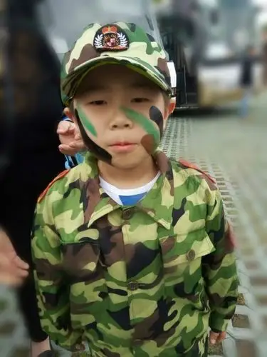 导游给小朋友脸上画迷彩妆了,好酷啊.化妆结束由教官带领训练.