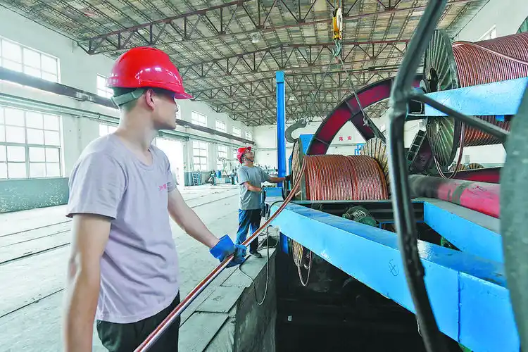 图为兴盛山鹰线缆有限公司工人正在生产电缆.