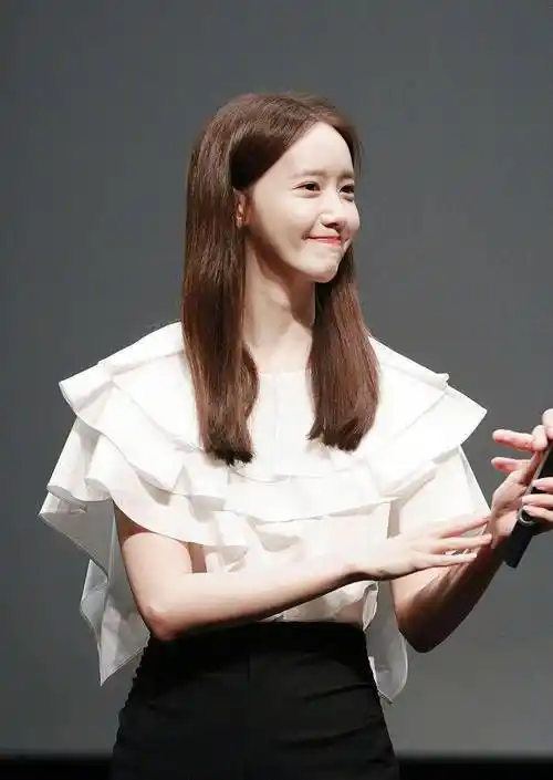 在舞台上的闪光灯聚焦下的林允儿,白皙的皮肤显得特别亮,一头棕色的