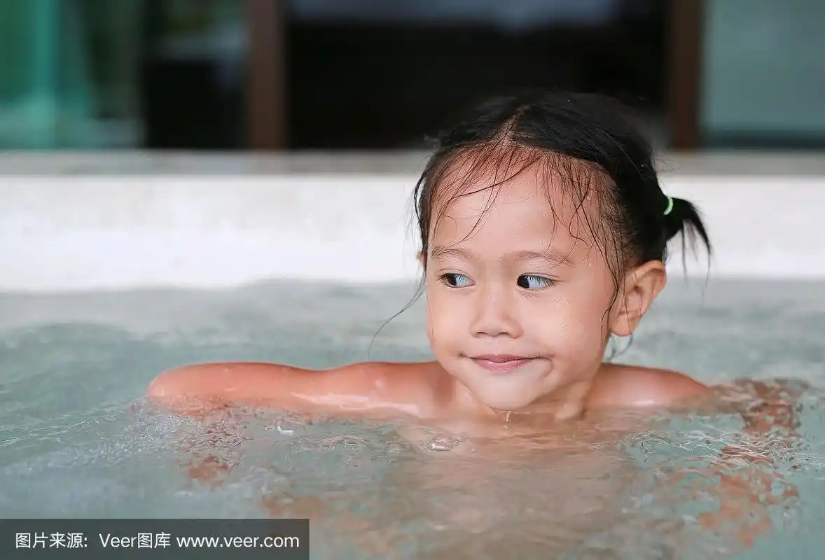 快乐的亚洲小女孩躺在热水浴缸里.