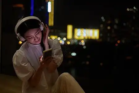 独居女性夜晚在窗边听歌图片素材