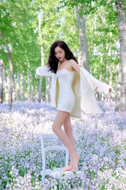吴宣仪穿吊带短裙置身花丛双腿修长身材好
