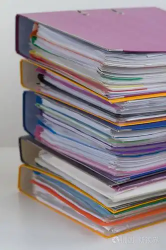 几个彩色文件夹, 其中的文件堆积在桌子上的一堆.特写