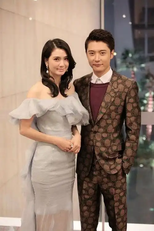 原创洪欣背万元包包与老公逛街秀恩爱,媒体指张丹峰不耐烦抽烟解闷