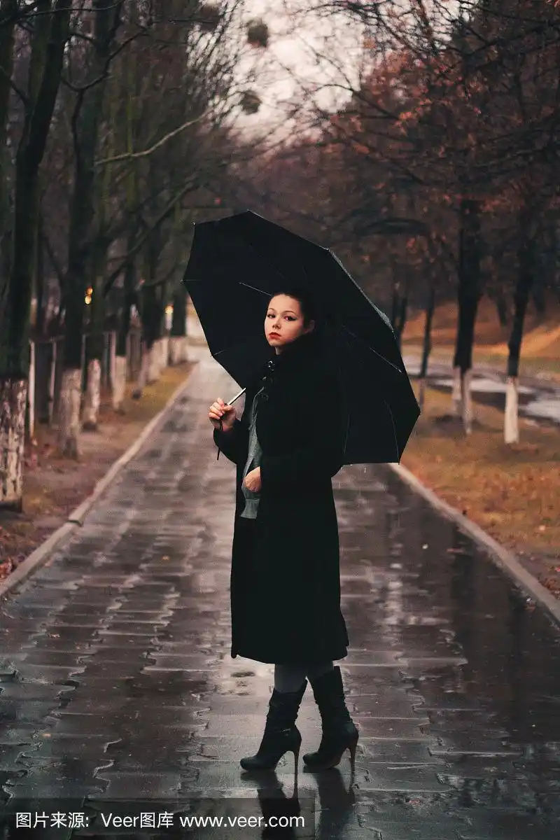 孤独的女人撑着伞站在雨中