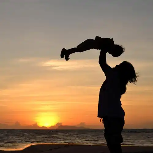 妈妈和小女孩,妈妈和小女孩在沙滩上的黄昏剪影.