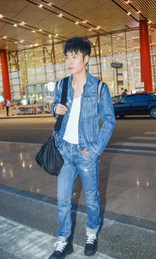 张丹峰罕见走机场,穿军绿色大衣配工装裤,39岁像中年大叔