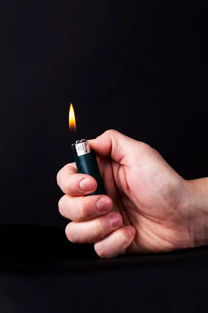 更轻的手,手捧着一个打火机熊熊燃烧的火焰