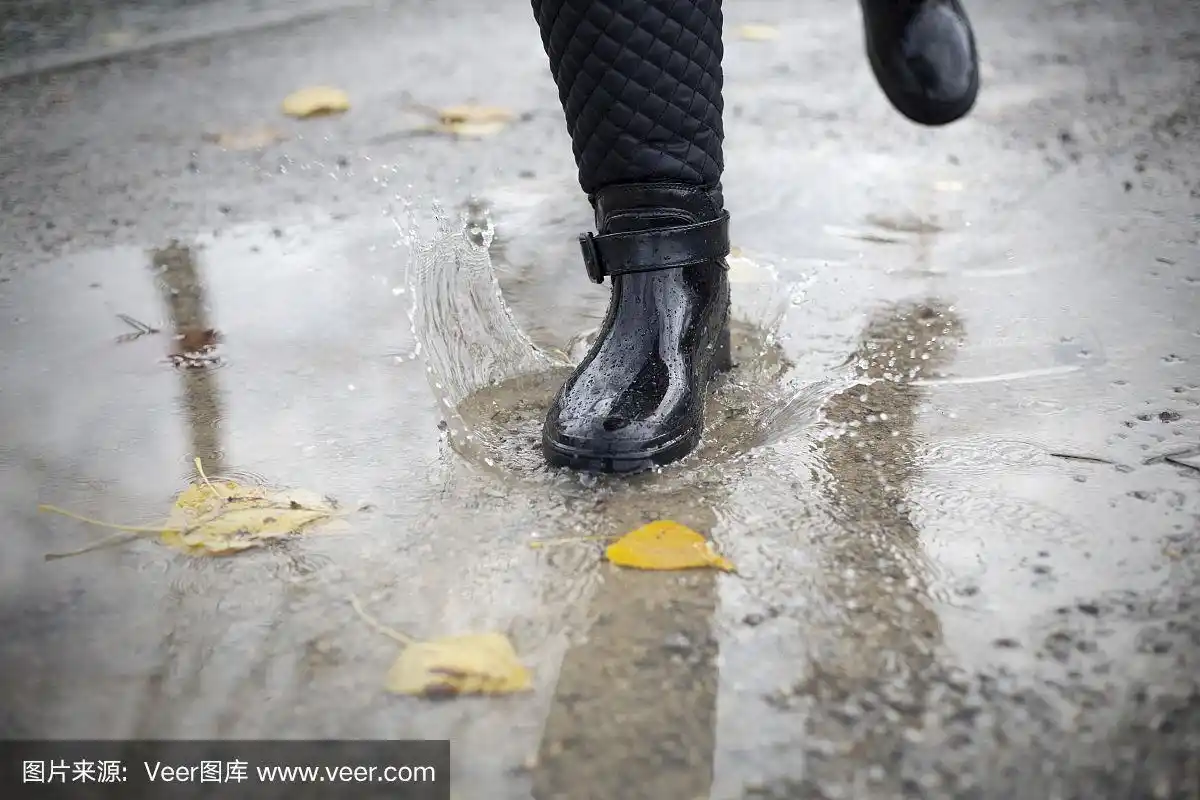 穿着女人的雨靴跳进水坑