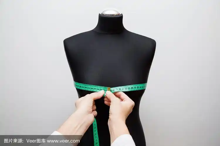 女人用绿色卷尺在黑色人体模型上测量胸围.正确的大小.