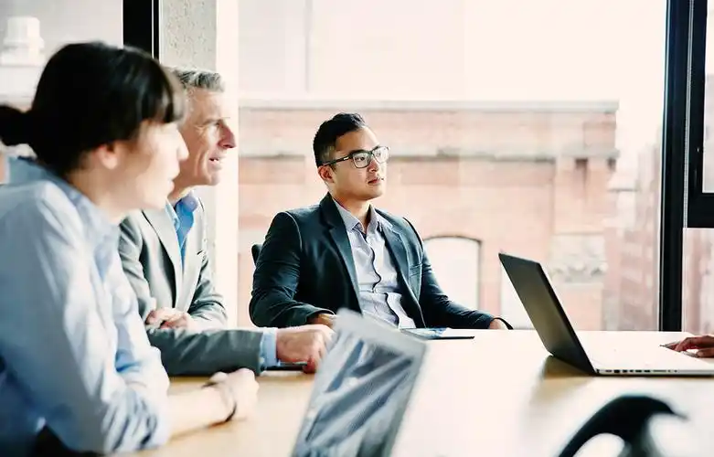 business people sitting around a table looking at a presentation