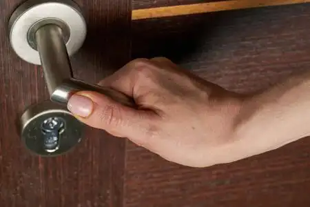 女人用手打开门把手或开门.照片