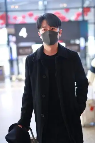 组图:黄轩素颜口罩遮面难掩帅气 全黑look造型独自拉行李接地气