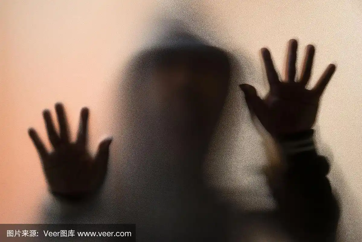 磨砂玻璃后面的危险人物.神秘人.万圣节的背景.模糊的照片