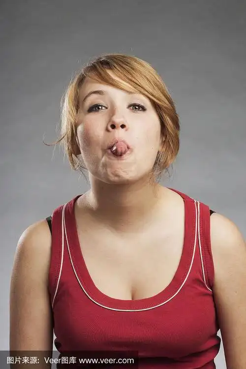 十几岁的女孩,红色背心伸着舌头,灰色背景