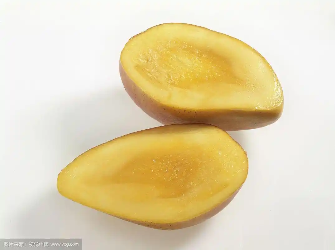 在白色的表面上,减半的黄色椭圆形芒果
