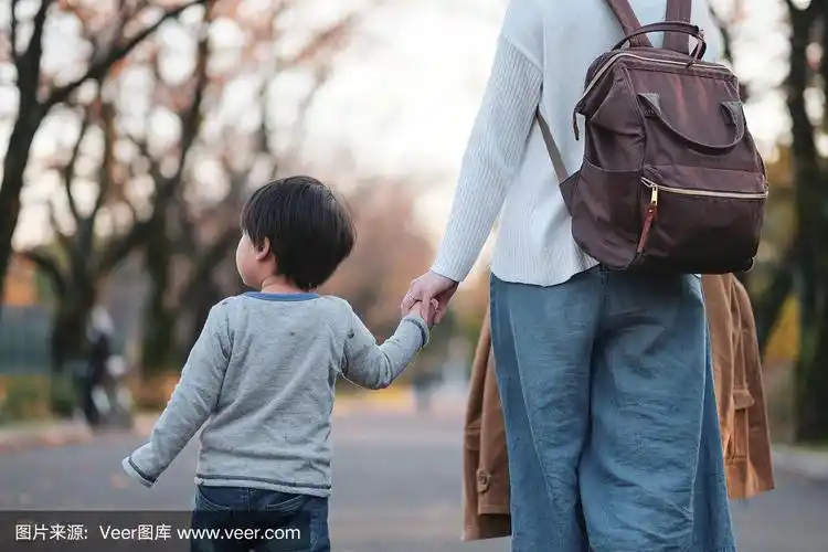 母亲和儿子手牵着手在公园里散步