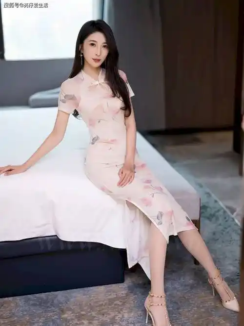 在一张静谧而唯美的照片中,一位年轻女子身着粉色旗袍,优雅地坐在白色