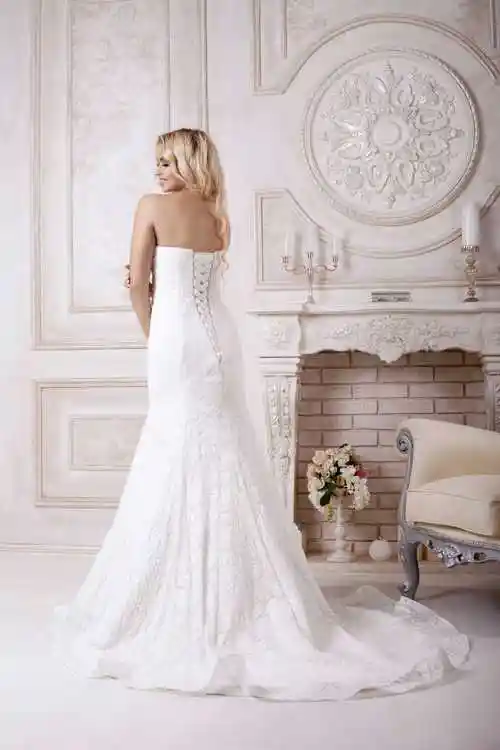 室内的壁炉旁边穿着婚纱的美女的背影